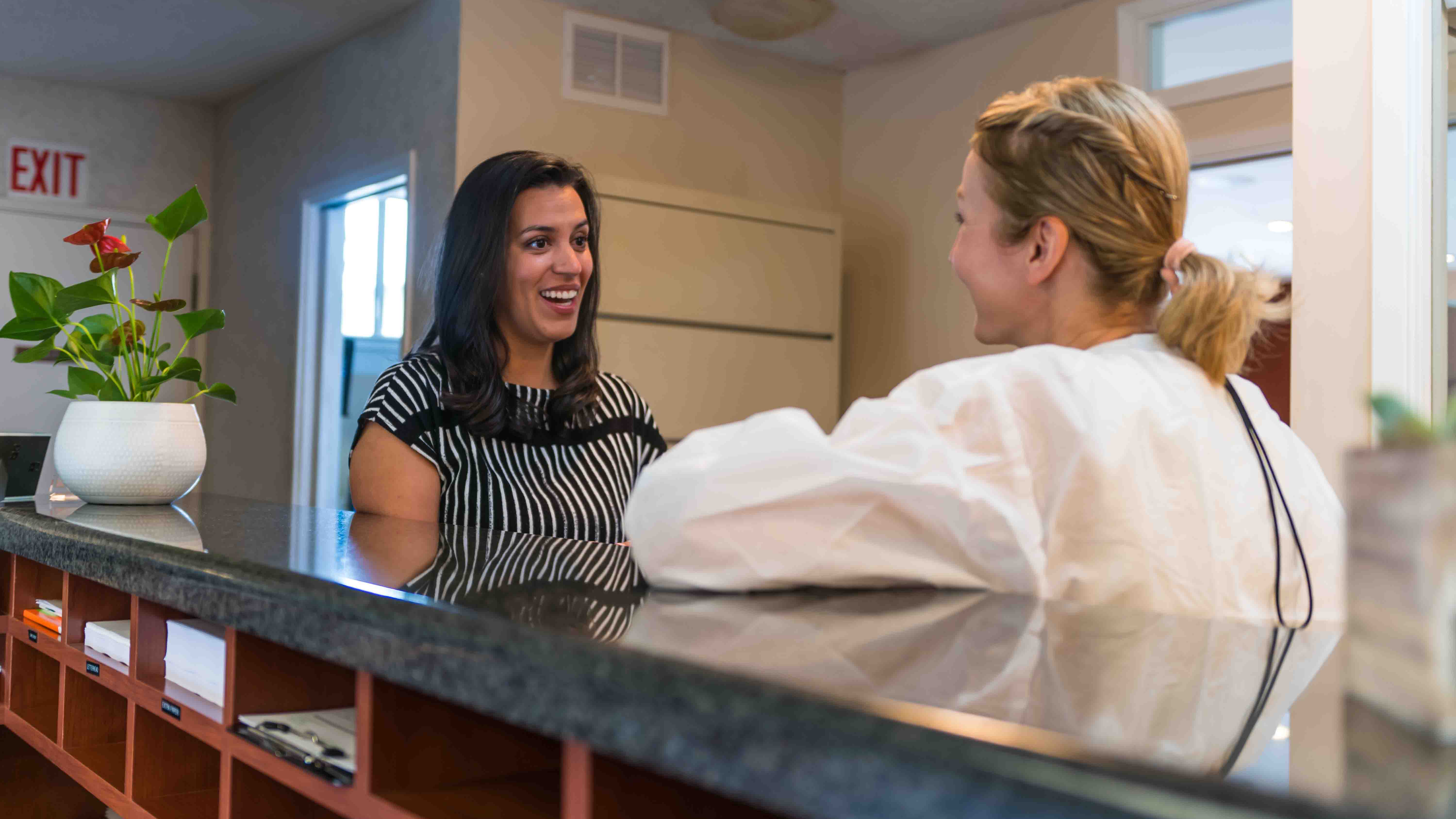 Photo of a female staff member laughing with a male patient.
