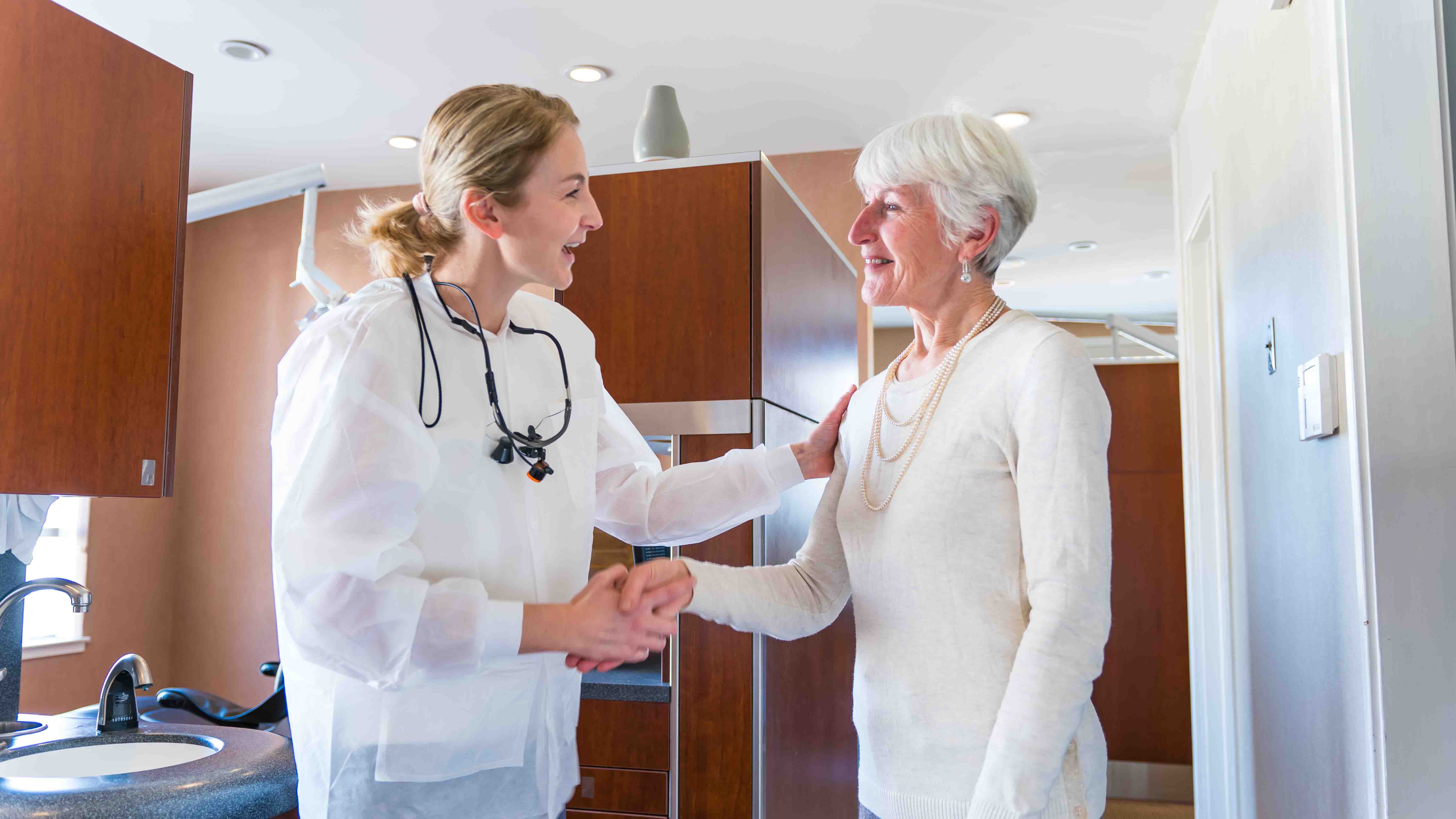 Photo of a female staff member laughing with a male patient.